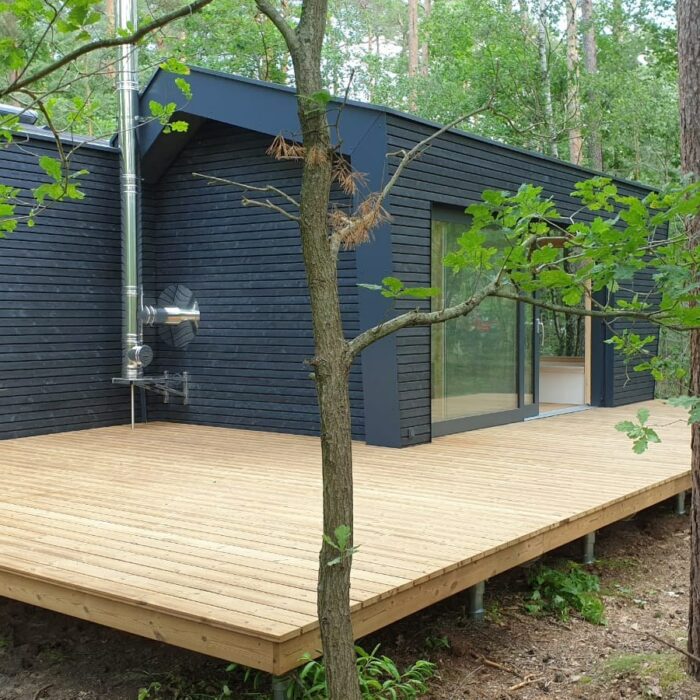 Modulhaus mit vorvergrauter Fassade, Satteldach und zwei Modulen im modernen Design in Natur.